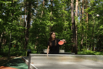 Fototapeta premium Ping pong player, engaged in a table tennis match, playing at a club with other enthusiasts.