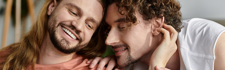 Fototapeta premium Two men share a tender moment, enjoying each other at home.