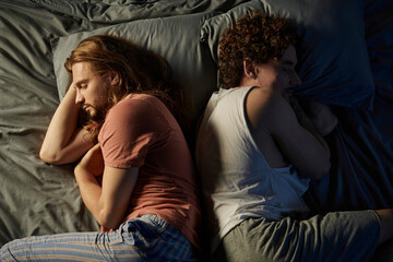 Two partners share a tender moment while resting peacefully at home.