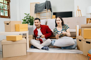 Asia young couple man and woman sit on couch use joystick controller play video game spend fun time together on sofa in living room. Asian married couple © laddawan