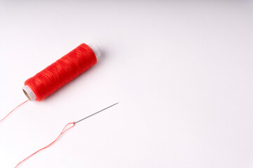 Colorful sewing thread set and needles isolated on background.