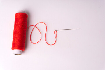 Colorful sewing thread set and needles isolated on background.
