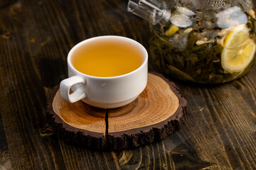 making green tea in a glass teapot with lemon and mint