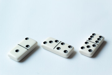 The game of dominoes is a table game involving rectangular pieces with dots that represent numbers. The objective is to match tiles with matching numbers. Photo with white background.