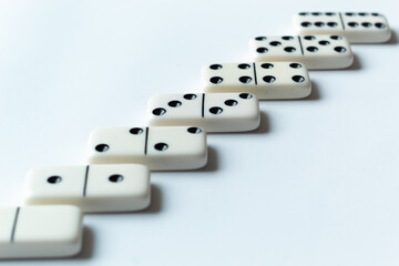 The game of dominoes is a table game involving rectangular pieces with dots that represent numbers. The objective is to match tiles with matching numbers. Photo with white background.