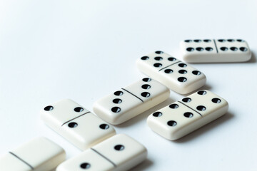 The game of dominoes is a table game involving rectangular pieces with dots that represent numbers. The objective is to match tiles with matching numbers. Photo with white background.