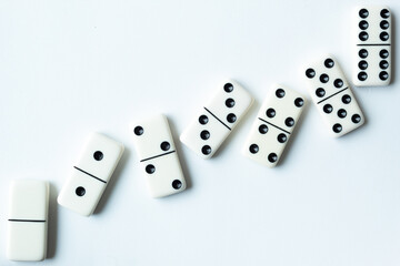 The game of dominoes is a table game involving rectangular pieces with dots that represent numbers. The objective is to match tiles with matching numbers. Photo with white background.