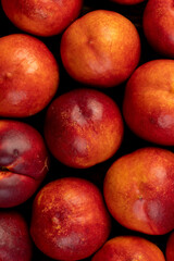 a large number of ripe soft nectarine fruits on the table