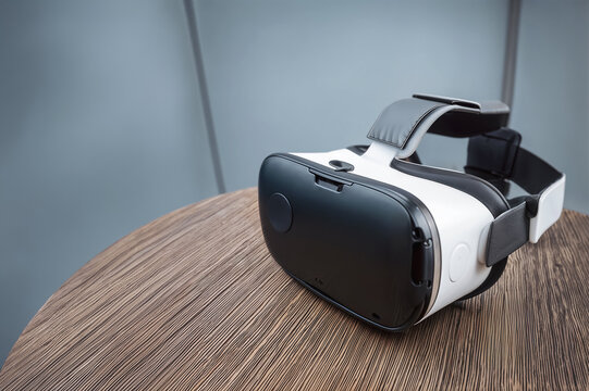 Casque de r&eacute;alit&eacute; virtuelle isol&eacute; sur une table en bois fond bleu gris clair