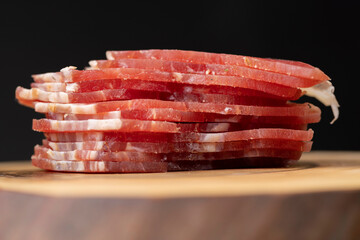 sliced ham with bacon on a board