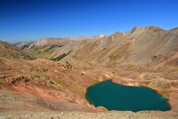 looking down on colorful lake como from hurricane pass on a sunny fall day along the alpine loop jeep trail in the rocky mountains of colorado, north of silverton