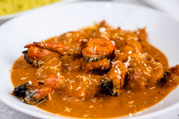 A vibrant plate of spicy shrimp curry, featuring plump shrimp and aromatic sauce with hints of coconut, garnished with grated coconut.