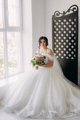 black-haired bride girl getting ready for groom in boudoir