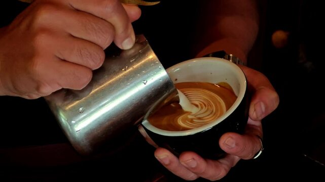 Barista making latte art, pouring cappuccino.