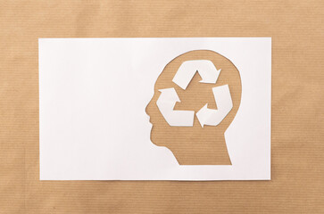 Eco-Friendly Concept with White Recycle Symbol in Human Head Silhouette on brown Paper Background