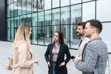 Group of young businesspeople stock market and exchange experts, leaders in modern science, finance and economy standing outside of office building. Staff members meeting businessman and businesswoman