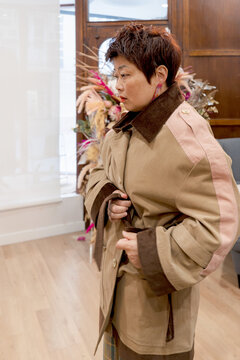Woman trying on a stylish jacket in a clothing store