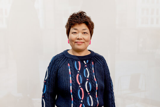Confident Woman in Blue Sweater Posing with a Warm Smile