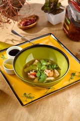 Delicious Shrimp Fish Soup with Cilantro Garnish in Green Bowl - Contemporary Rustic Setting
