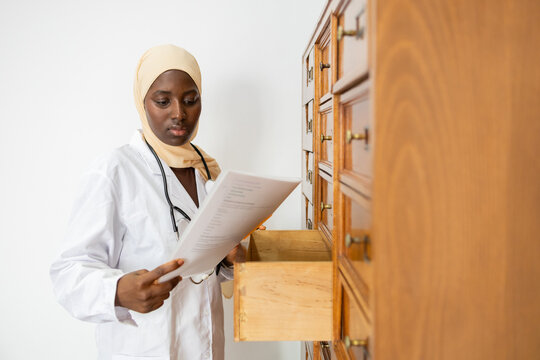 Black female doctor reviewing files in a storage room
