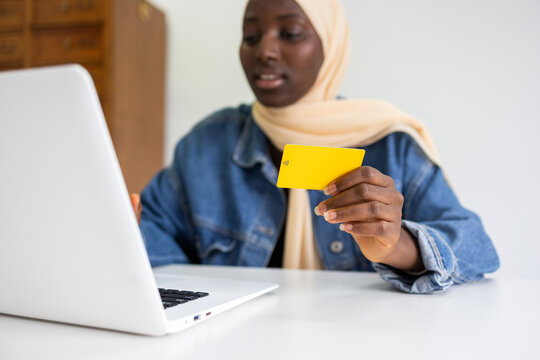 Black female professional working online holding a credit card