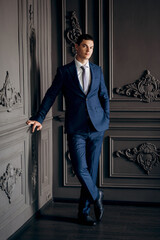 portrait of groom in blue three piece suit with tie on wedding day