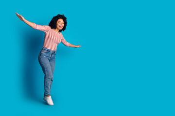 Photo of lovely cheerful girl wear stylish clothes going string empty space isolated on blue color background