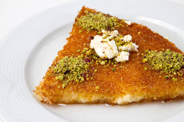 Künefe is a traditional dessert made from cheese pastries soaked in sugar-based sweet syrup. Turkish cheese dessert