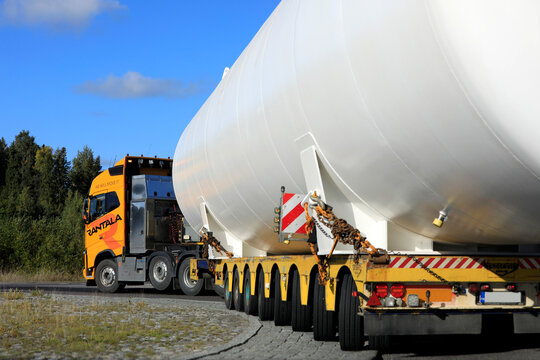 Volvo FH trucks hauls oversize load transport of a LNG storage tank on Broshuis low loader trailer in roundabout. 