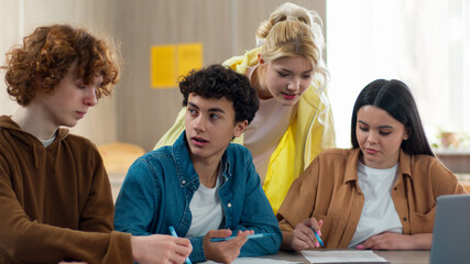 Four students friends girls females Caucasian boys guys males pupils sitting in school university college academy class talking argue discuss problem studying laptop learning prepare exams difficult