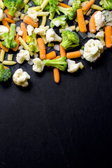 Frozen vegetables on dark table