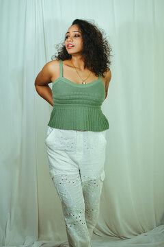 Fashion photoshoot of a young Indian woman with curly hair wearing a green dress.
