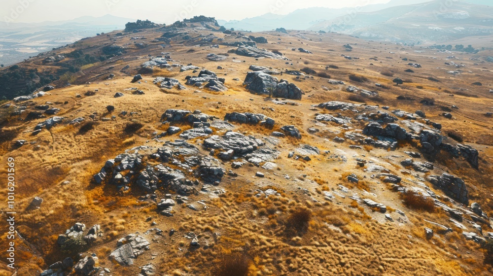 Poster A High Angle View of a Rocky Hillside with Dry Grass and a Hazy Distant Mountain Range