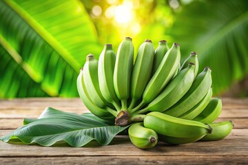 Green bananas on top of wooden table with green leaf background
