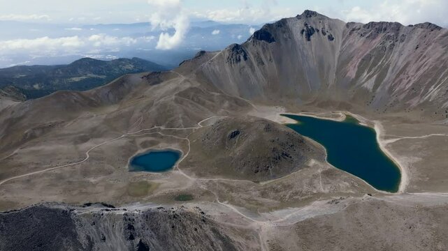 Backward drone flight over Nevado de Toluca, revealing Laguna del Sol and Laguna de la Luna in Mexico.