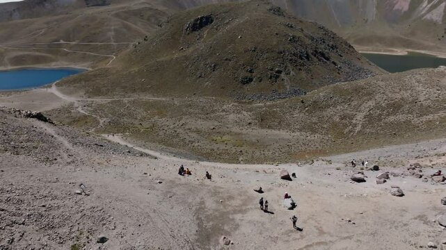 Orbit aerial view of people resting and admiring Laguna de la Luna and Laguna del Sol at Nevado de Toluca, Mexico