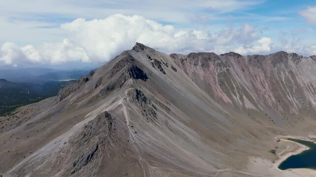 Pan right dolly-in flight reveals Toluca Peak, Laguna del Sol, and high-altitude mountain scenery at Nevado de Toluca, Mexico