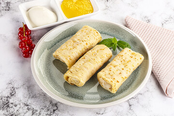 Homemade stuffed pancakes with honey and cream sour