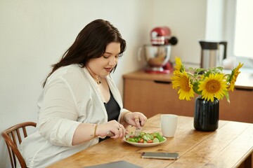 A beautiful woman savoring a delicious salad while sitting at her dining table.