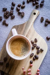 Tasse de café chaud sur la table avec des grains de café