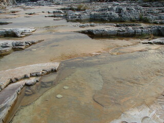 Water flowing in the river bed with brown stones in Minas Gerais, Brazil