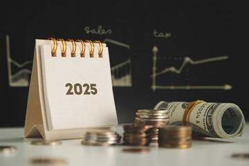 finances and plans for 2025. calendar and coins on the table