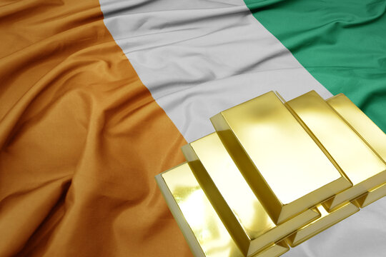 shining golden bullions on the ivory coast flag background. gold reserves. - Powered by Adobe
