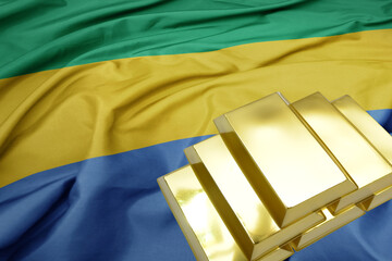 shining golden bullions on the gabon flag background. gold reserves.