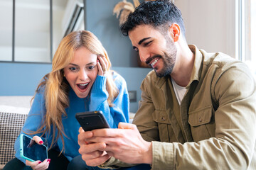 Couple Reacting Excitedly to Something on Their Smartphones
