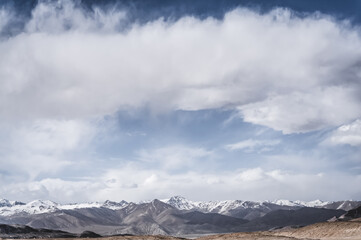 Fototapeta premium Panoramic landscape of textured Tien Shan mountains in Pamir in Tajikistan, panoramic landscape of a mountain range with snow and glaciers in summer