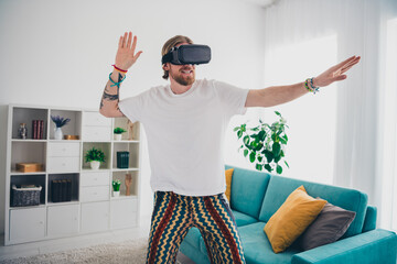 Photo of attractive young male play vr game playful dressed sleepwear cozy day light home interior...