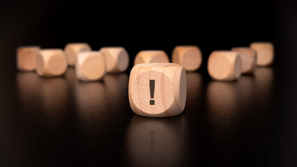 concentrate on a wooden block featuring an exclamation mark symbol, signifying urgency