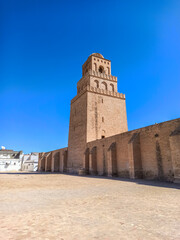 Obraz premium The Great Mosque of Kairouan, also known as the Mosque of Uqba, is a significant Islamic landmark built in the 7th century. It features an ancient minaret, marble columns, and beautiful domes. 