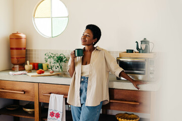 Relaxed mature woman enjoying Brazilian coffee in the kitchen